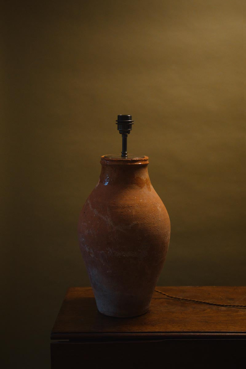 Handcrafted earthenware clay pot lamp with a weathered ceramic base and soft beige lampshade, perfect for Mediterranean-inspired interiors